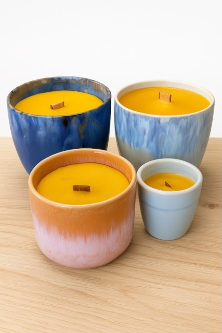 Wabenflammen Knisterkerze Bunte Kerzen in verschiedenen Tontöpfen, mit gelbem Wachs und Holzdochten.
